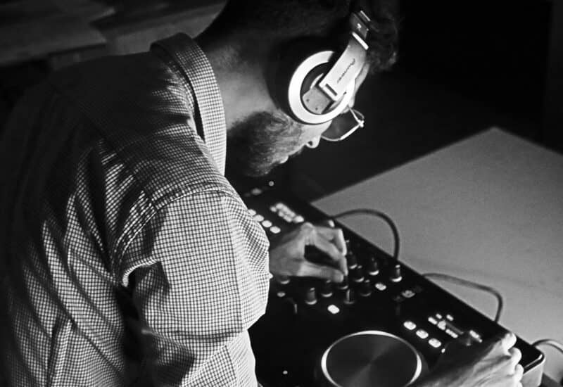 man with headphones with an audio Image of someone working an audio board, wearing headphones